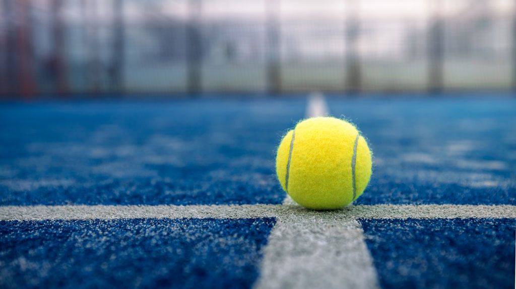 yellow-ball-on-floor-behind-paddle-net-in-blue-court-outdoors-padel-tennis-is-racquet-game-professional-sport-concept-1024x575-2.jpeg